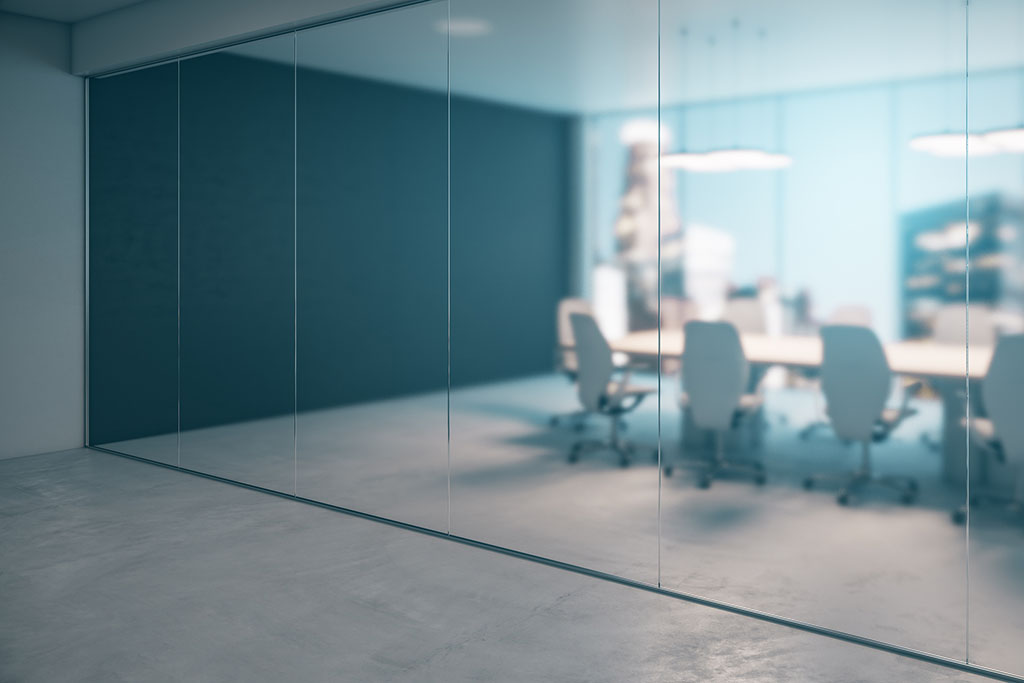 Side view of meeting room with modern furniture behind a blurred glass partition.